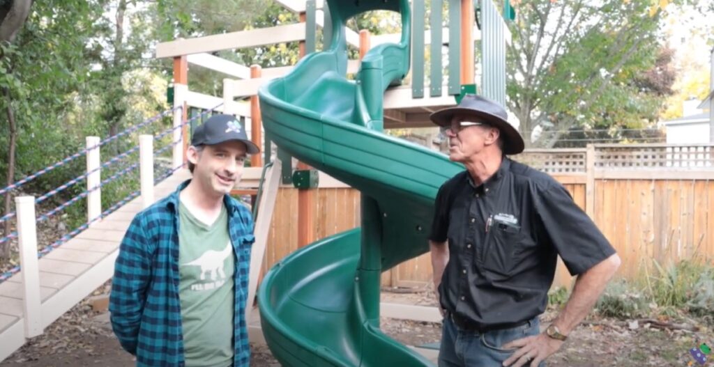 talking in front of a green playset